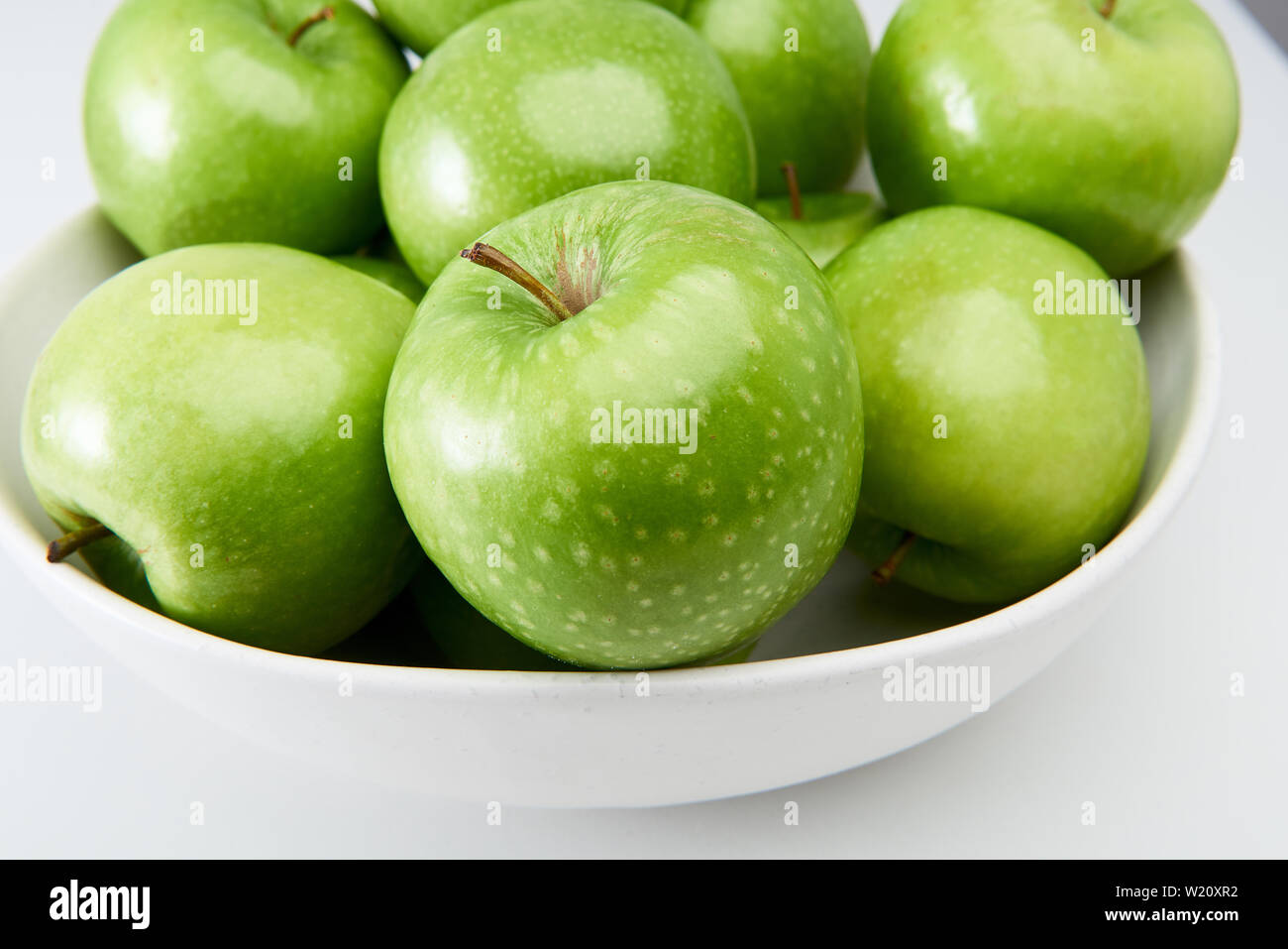 Verde Granny Smith mele di cottura in una ciotola bianco close-up da sopra. Foto Stock