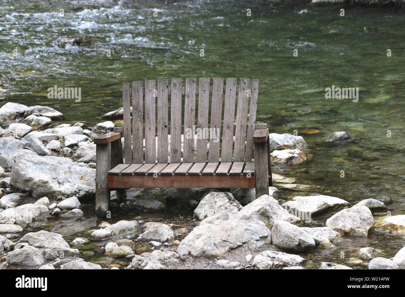 In legno antico banco adirondack dal fiume, Big Sur, California. Foto Stock