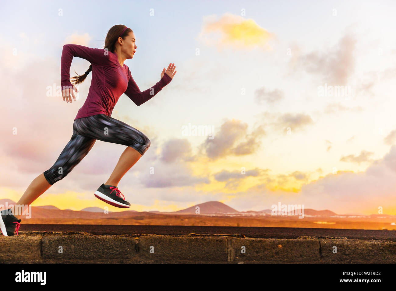 Atleta trail running silhouette di donna runner al tramonto sunrise. Cardio fitness training di maratona gara sportive. Attiva uno stile di vita sano in estate natura all'esterno. Foto Stock
