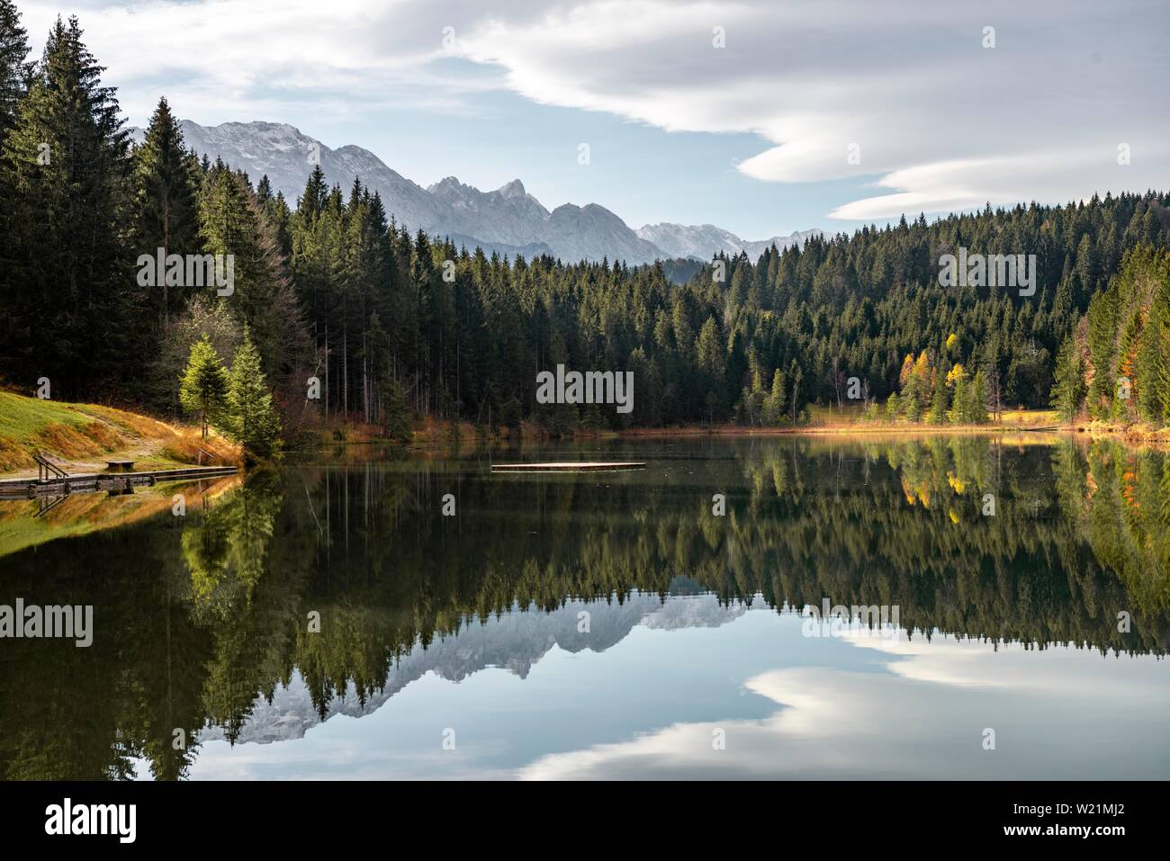 Montagne e foreste sono riflesse nel lago calmo Grubsee vicino Krun, Karwendel, Alta Baviera, Baviera, Germania Foto Stock