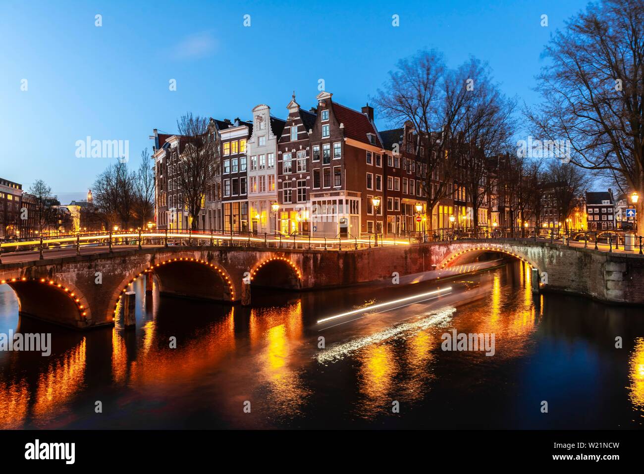 Atmosfera serale, tracce di luce, crociere in barca attraverso il canal con bridge, Keizersgracht e Leidsegracht, canal con case storiche, Amsterdam, Nord Foto Stock