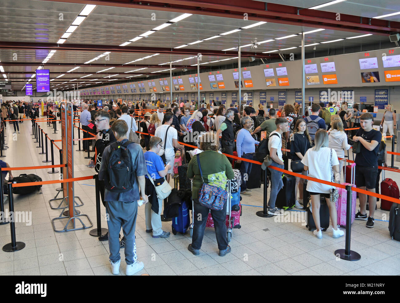 L'aeroporto London Luton, Regno Unito, check-in sala. I passeggeri Easyjet coda per il check-in per i voli. Luton di check-in hall ha 62 scrivanie in una singola linea. Foto Stock