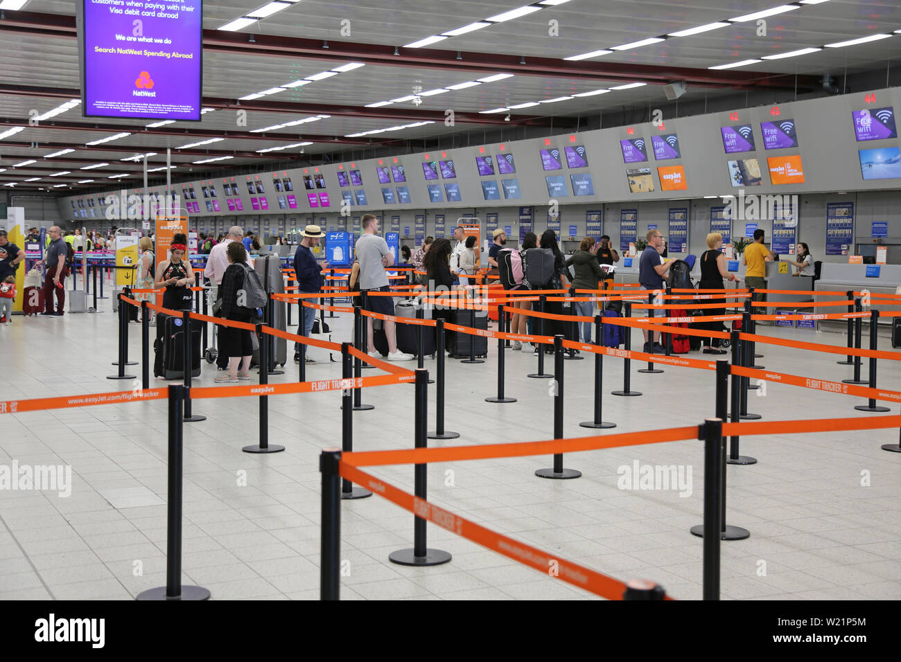 L'aeroporto London Luton, Regno Unito, check-in sala. I passeggeri Easyjet coda per il check-in per i voli. Luton di check-in hall ha 62 scrivanie in una singola linea. Foto Stock