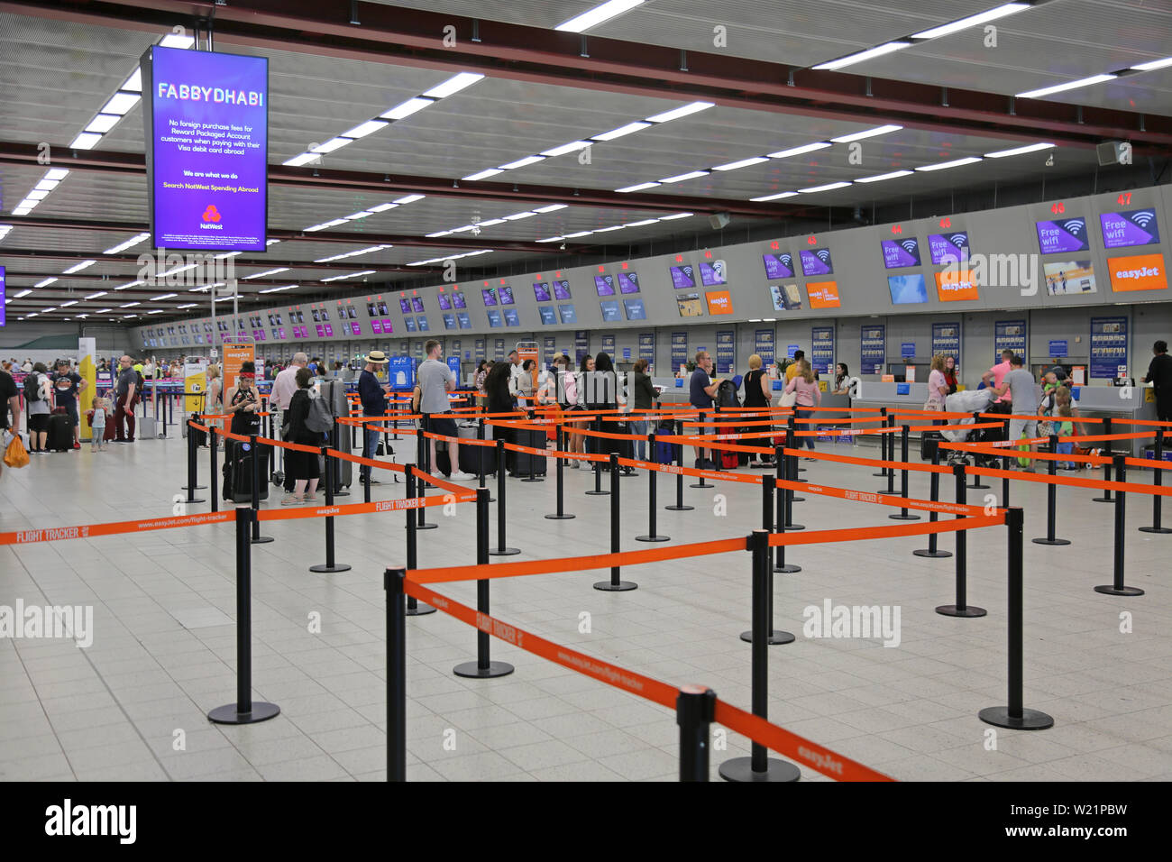 L'aeroporto London Luton, Regno Unito, check-in sala. I passeggeri Easyjet coda per il check-in per i voli. Luton di check-in hall ha 62 scrivanie in una singola linea. Foto Stock