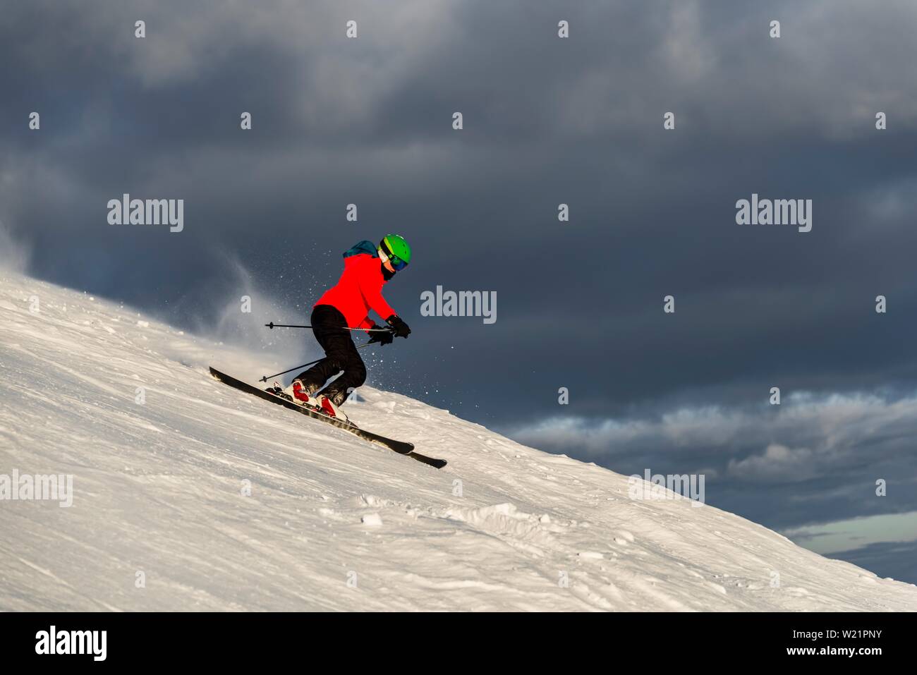 Sciatore femmina sci ripida discesa, pista nera, dietro le montagne, Brixen im Thale, Tirolo, Austria Foto Stock