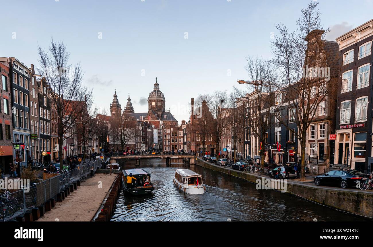 Strada panoramica Oudezijds Voorburgwal al canal con barche, la chiesa di San Nicola in retro, Amsterdam, Olanda Settentrionale, Paesi Bassi Foto Stock