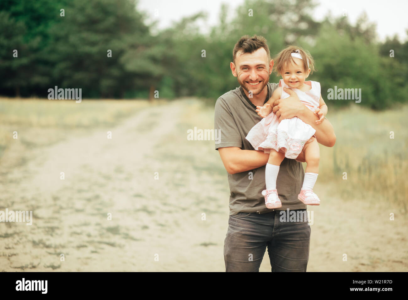 Il padre con la sua piccola figlia nelle sue braccia per divertirsi in una passeggiata nella foresta. Copia dello spazio. Foto Stock