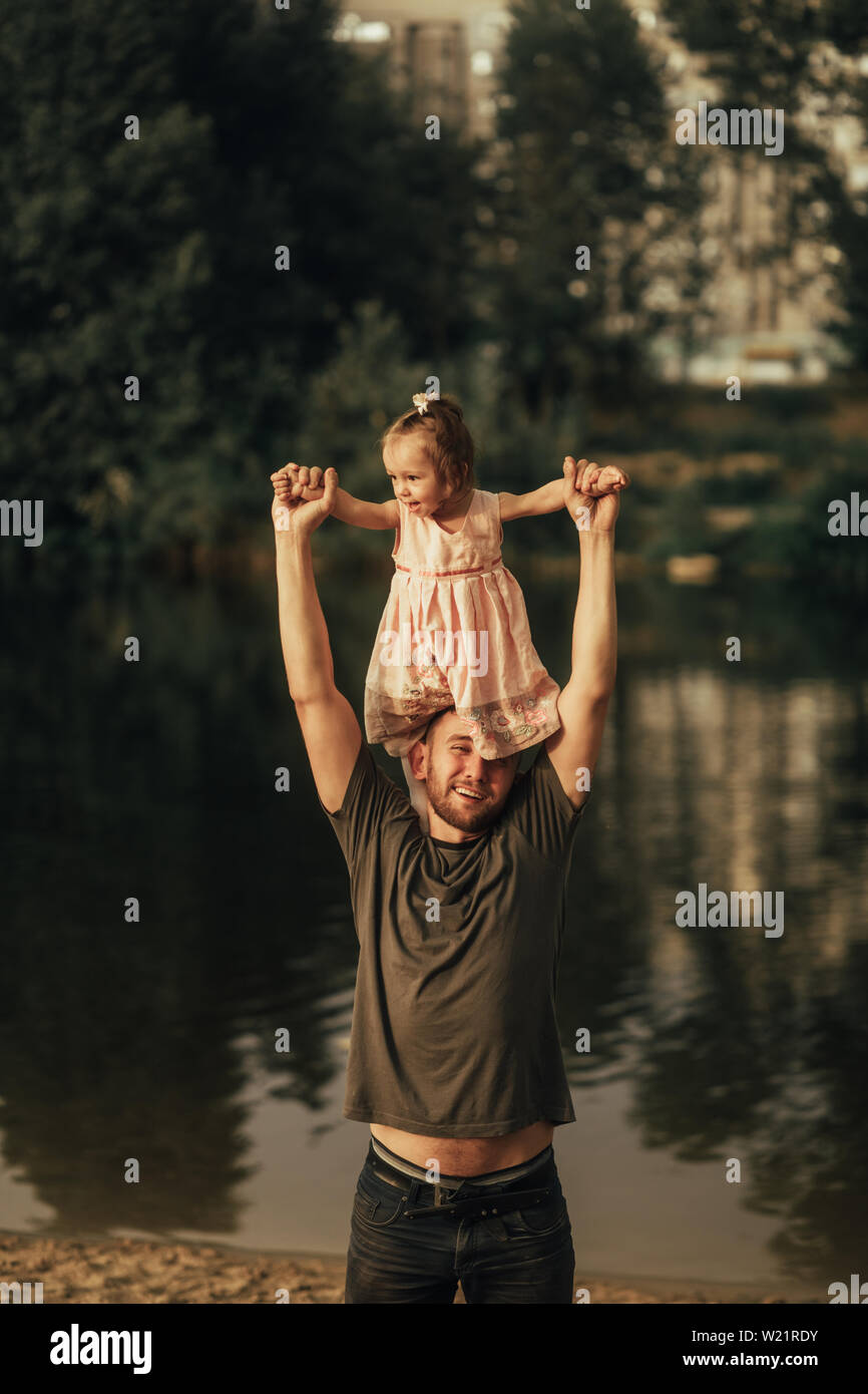 Il padre con la sua piccola figlie si trova sulla passeggiata accanto al lago. Foto Stock
