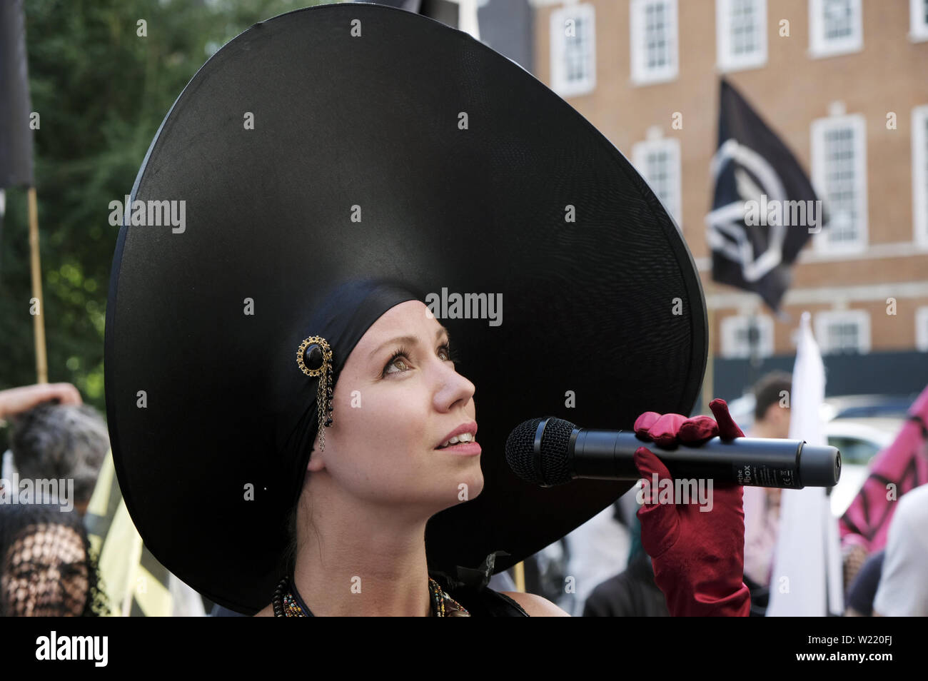 London, Greater London, Regno Unito. 2 Luglio, 2019. Attivista ambientale contiene un microfono durante una manifestazione di protesta a Londra.la ribellione di estinzione gli ambientalisti hanno marciato in un corteo silenzioso denominate " XR Carmen la processione di carbonio'' attraverso il centro di Londra per visitare 5 diversi uffici di petrolio società tra cui ENI, CPCN, SAUDI ARAMCO, Repsol, BP. Hanno fermato presso la sede centrale di olio per dichiarare un 'crime scene'' e consegnare una lettera e copie della XR handbook. Attivista ambientale richiesta da società petrolifere per smettere di esplorare di più combustibili fossili. (Credito Immagine: © Andres Foto Stock