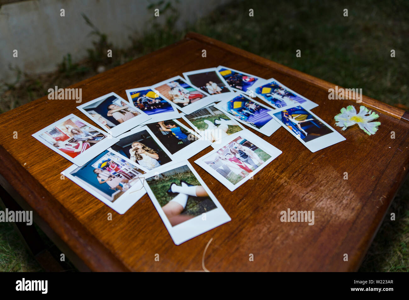 Raccolta di foto polaroid immagini prese da un istante fotocamera, visualizzata su un tavolo di legno Foto Stock