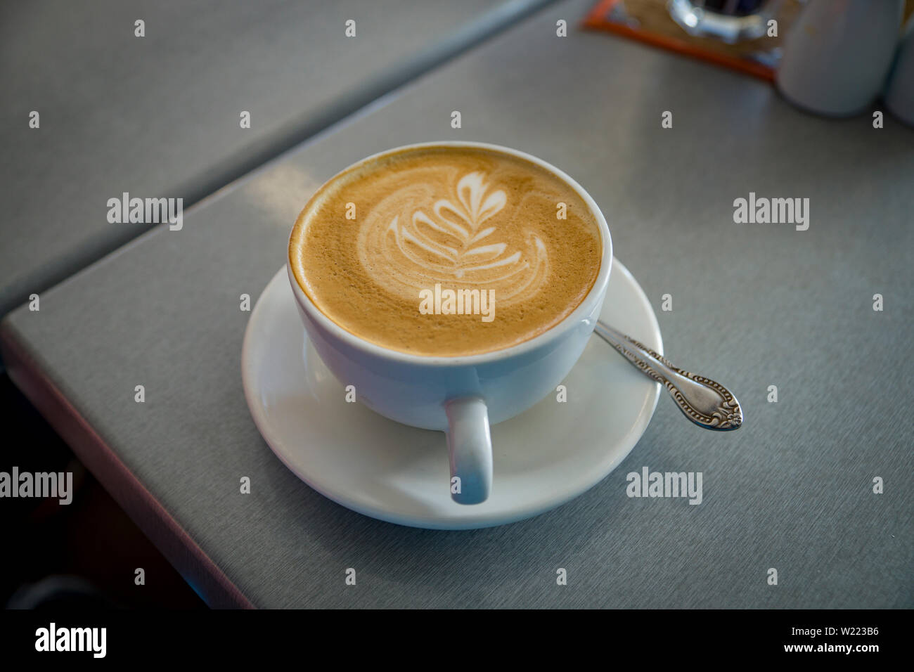 Piatto bianco caffè nella tazza bianca in una Nuova Zelanda cafe Foto Stock