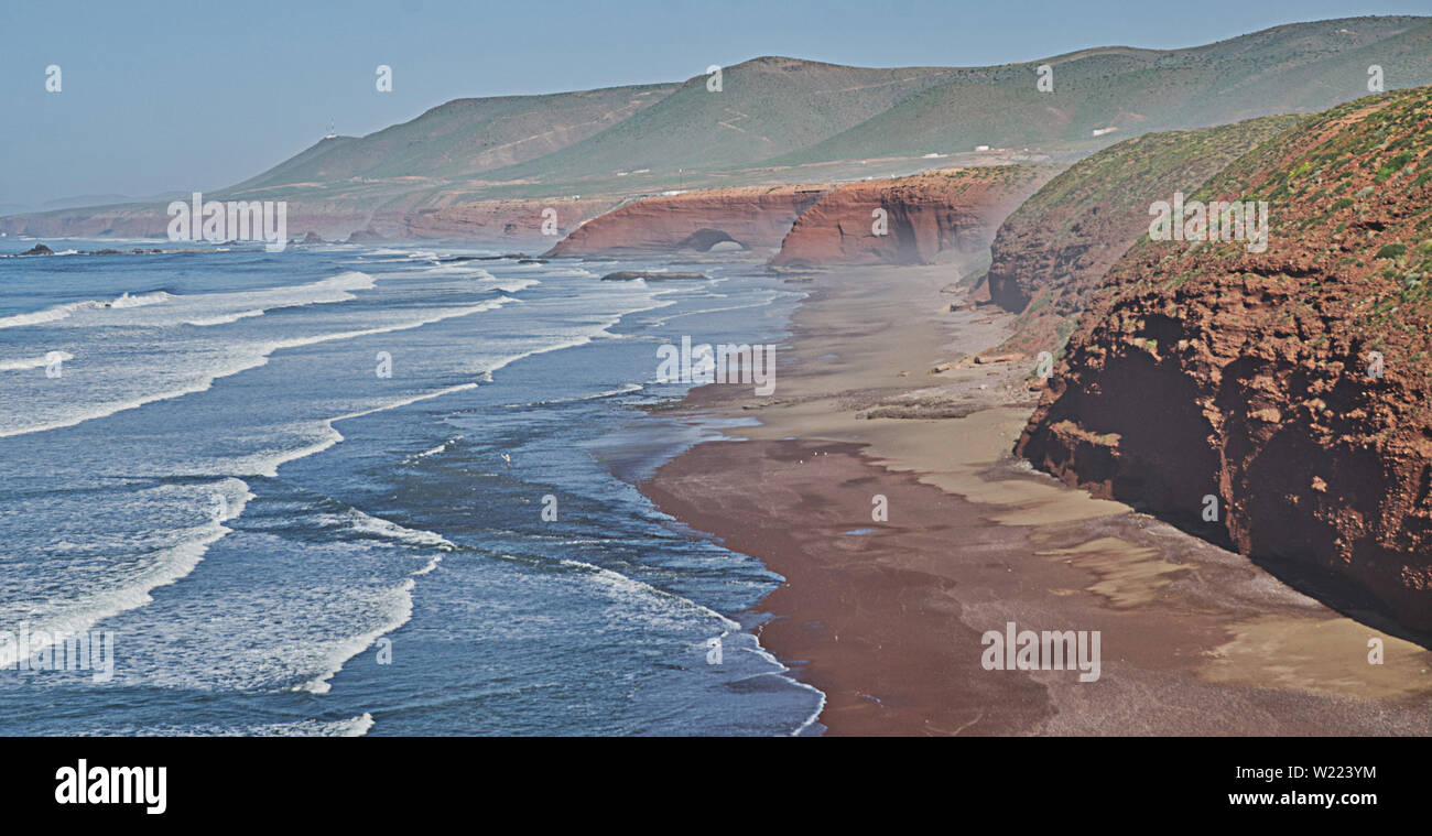 Red Rock con formazione di arco sulla spiaggia, Plage Sidi Ifni, Marocco, Africa Foto Stock