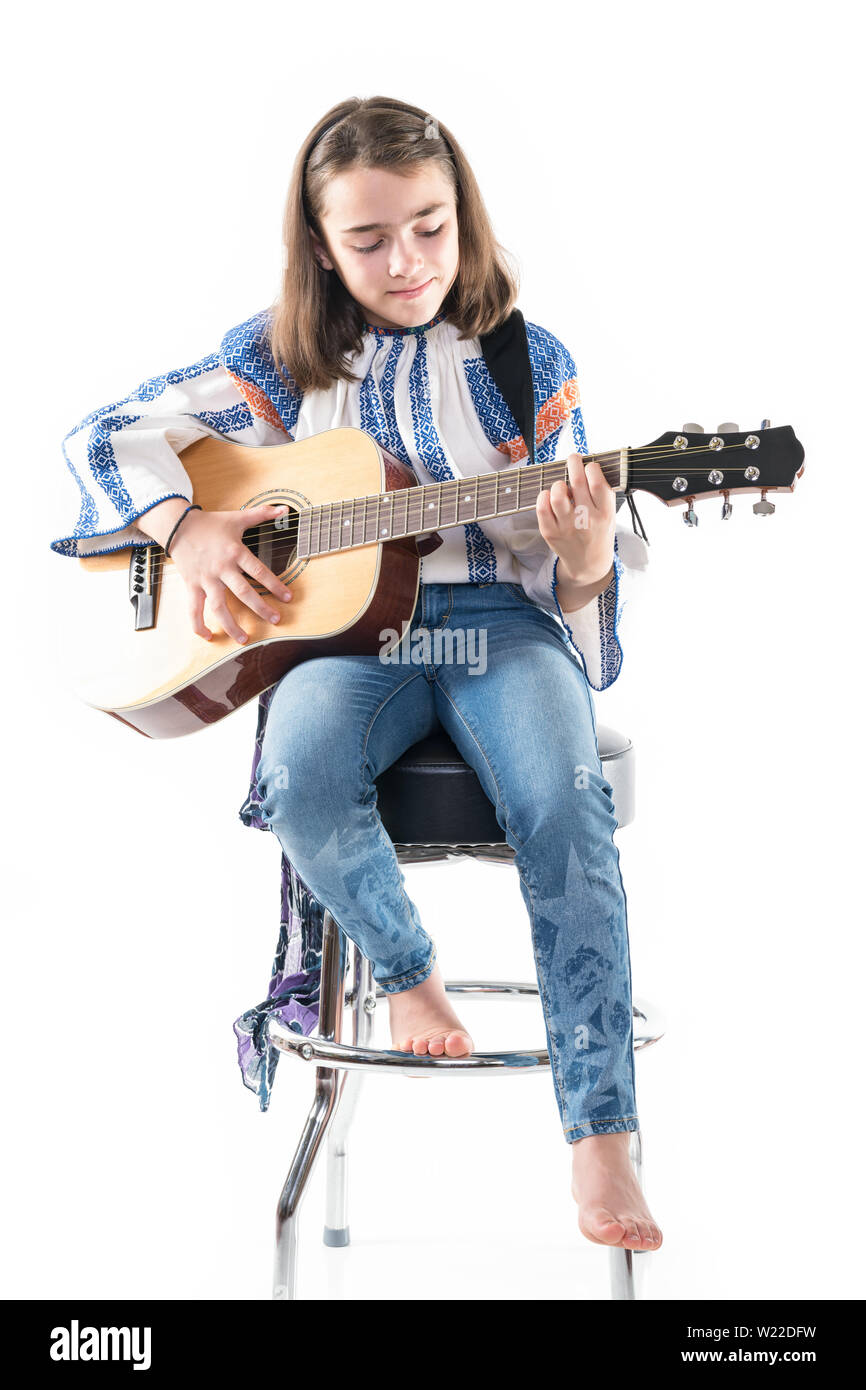 Preteen ragazza che gioca la sua chitarra isolato su uno sfondo bianco. Foto Stock