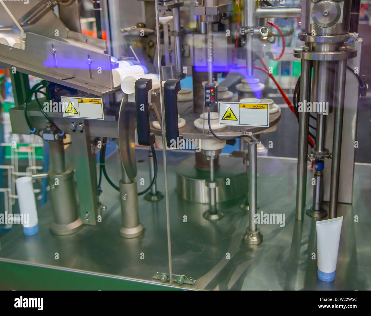 Il processo automatico di tubi cosmetici riempitrice e sigillatrice Foto Stock