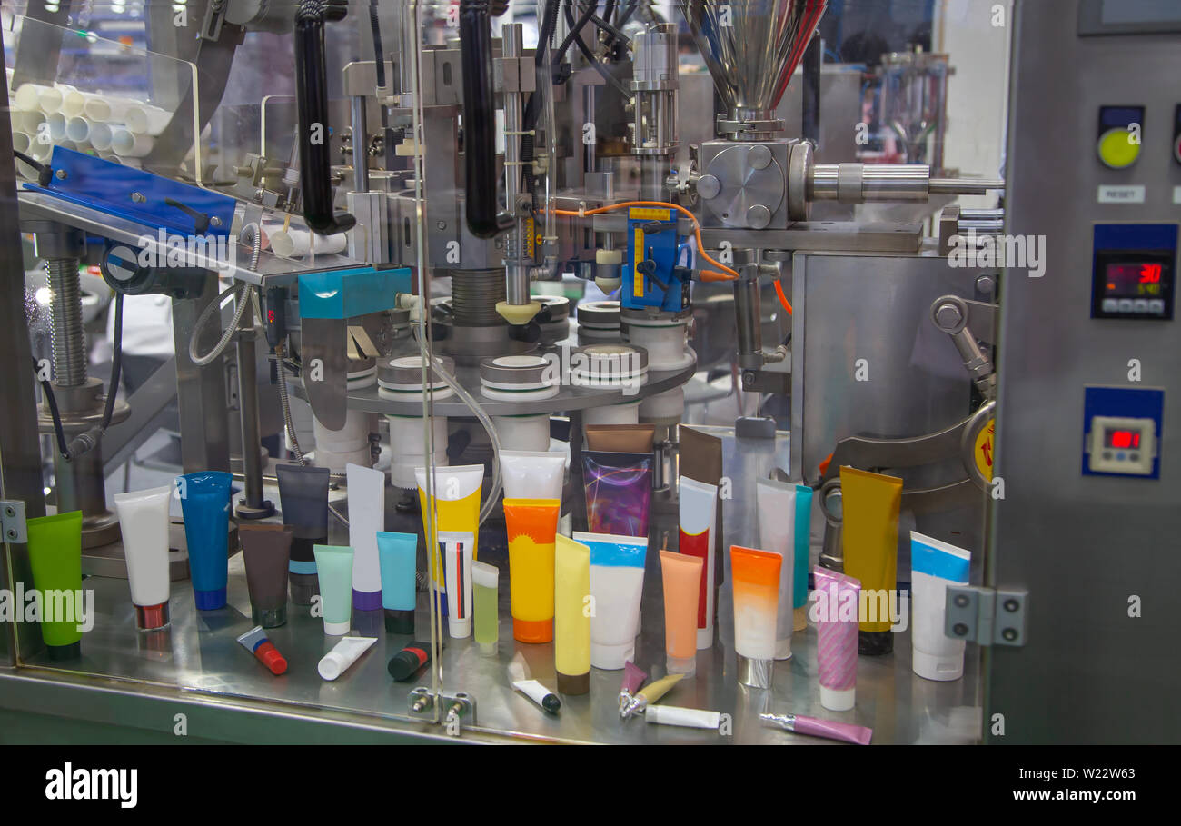 Il processo automatico di tubi cosmetici riempitrice e sigillatrice Foto Stock