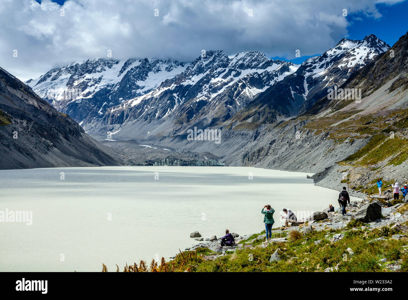 Walkers arriva a Hooker del lago alla fine dell'Hooker Valley via, Aoraki Monte Cook, isola del Sud, Nuova Zelanda Foto Stock
