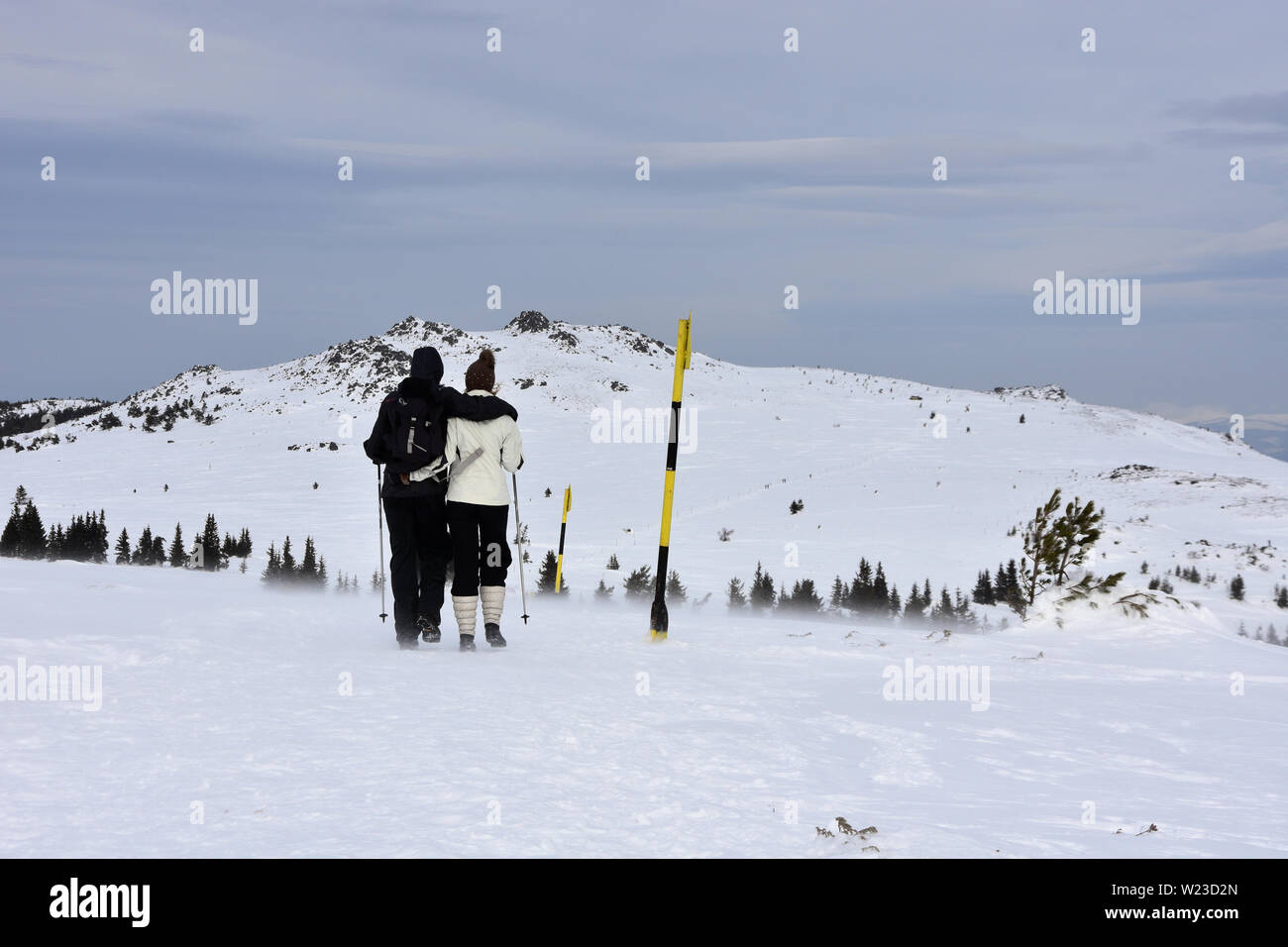 Giovane coppia escursioni in inverno, tempo severo con neve e vento raffiche alte sul Monte Vitosha Platiou, Bulgaria Foto Stock