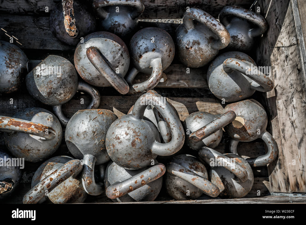 Molti pesi kettlebells background in palestra all'aperto. Texture di stell pesi liberi per il sollevamento pesi sdraiato sul pavimento al centro fitness per la formazione incrociata. Foto Stock