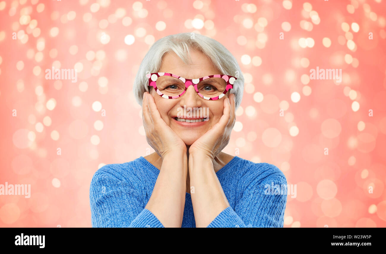 Stupiti funny senior donna con grande festa bicchieri Foto Stock