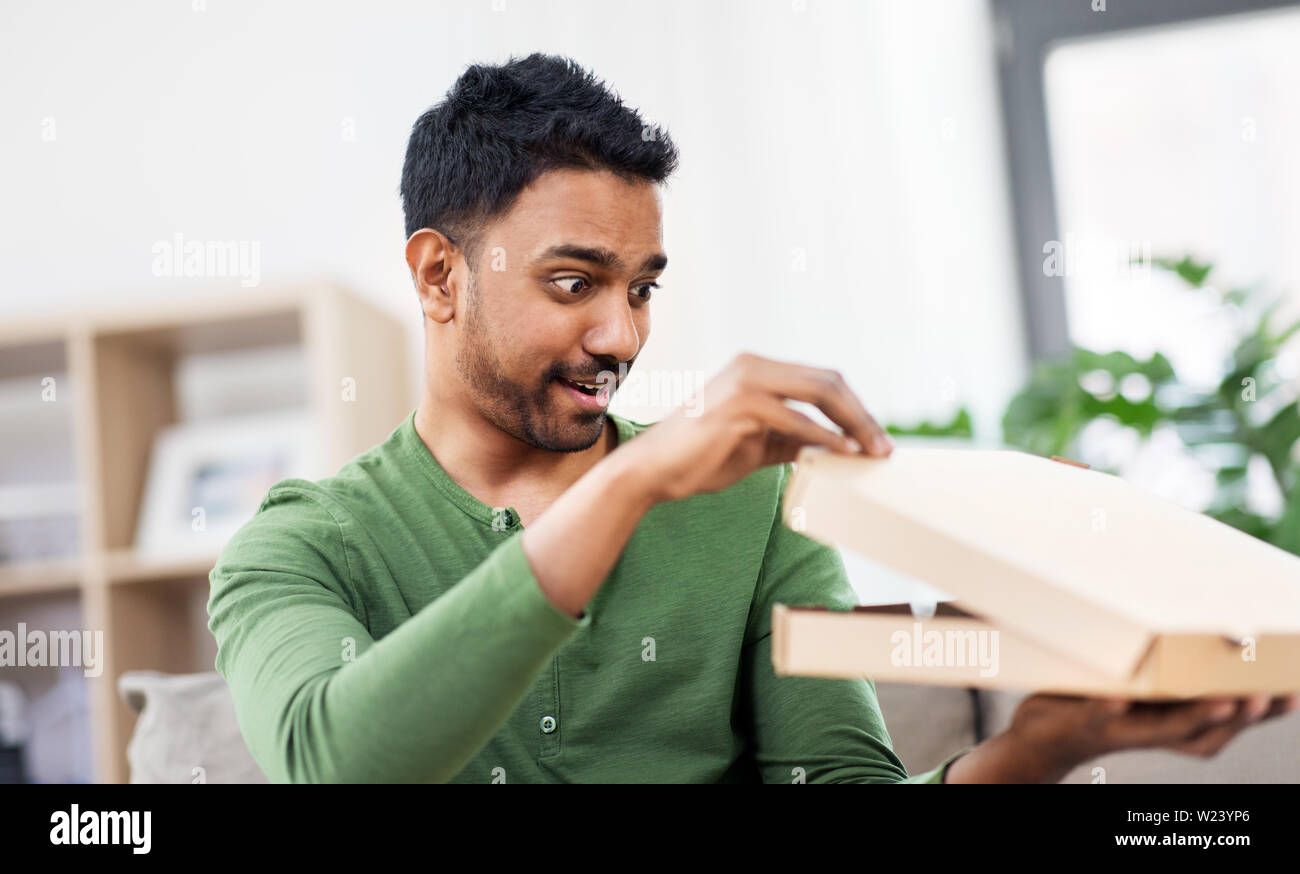 Indian uomo cerca all'interno della pizza da asporto box Foto Stock