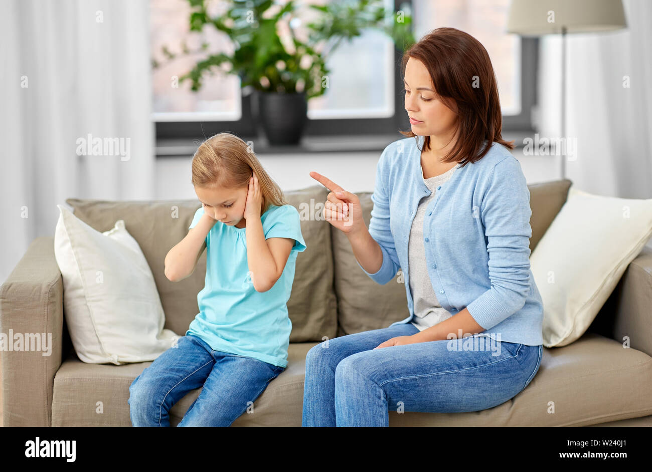 Arrabbiato madre scolding sua figlia a casa Foto Stock