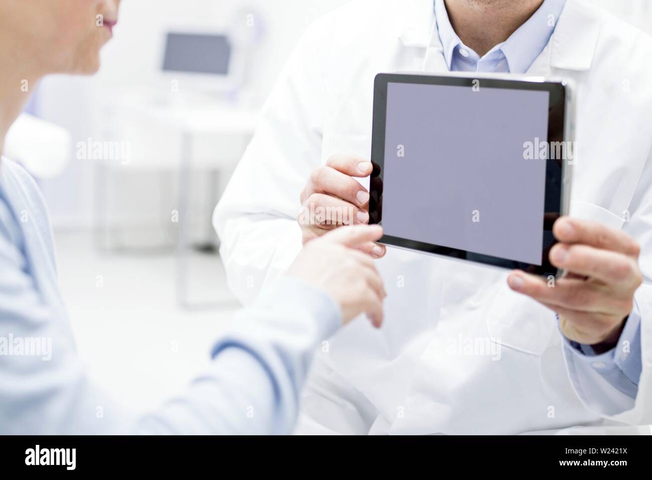 Medico mostra digitale compressa al paziente. Foto Stock