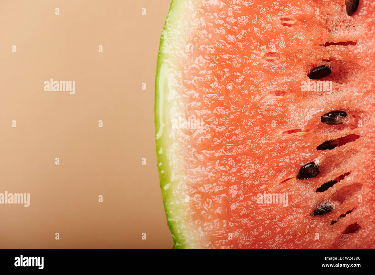 Fresca anguria succosa pezzo vista macro su sfondo marrone Foto Stock