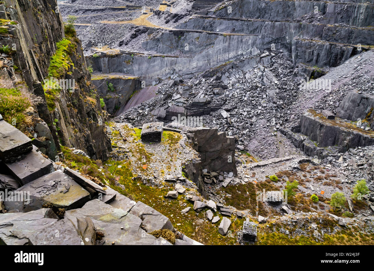 Semi-vista in verticale verso il basso in una grande galleria a cielo aperto a Dinorwic cava di ardesia, con banchi multipli sulla faccia di lavoro visibile. Foto Stock