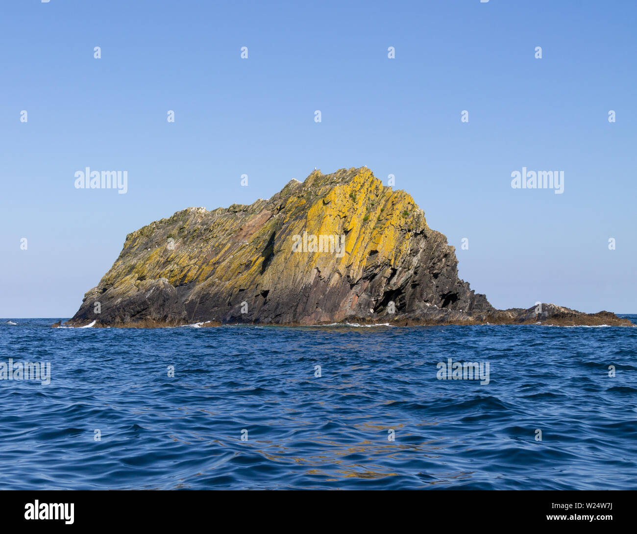 Formazione di roccia chiamato Black Rock rising dall'Oceano Atlantico off lungo la costa sud occidentale dell'Irlanda Foto Stock