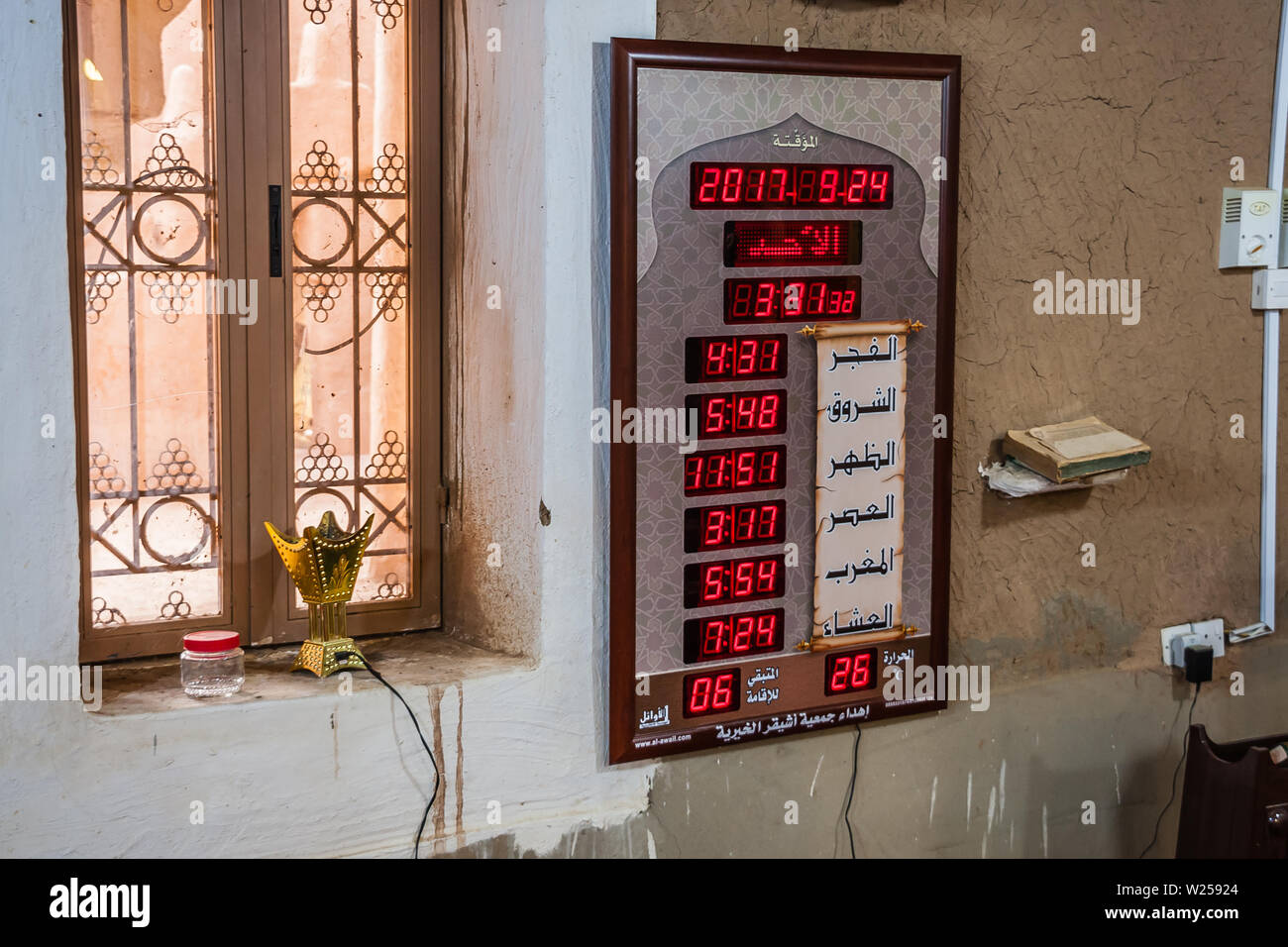 Un display elettronico che mostra il tempo di preghiera nella moschea restaurata di mattoni di fango del Villaggio Patrimonio di Ushaiqer, Arabia Saudita Foto Stock