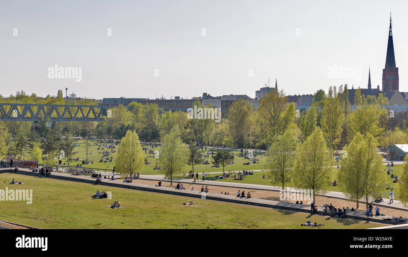Berlino, Germania - 18 Aprile 2019: Le persone hanno un periodo di riposo in Schoneberger Meadow park, American chiesa in background. Berlino è la capitale e la più grande Foto Stock