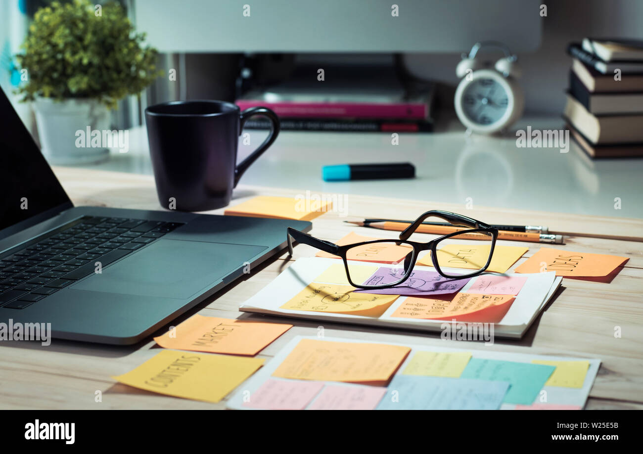 Piano di lavoro con il computer portatile e il Blocco note,tazza di caffè al mattino.business plan,strategia concetti/nessuno Foto Stock