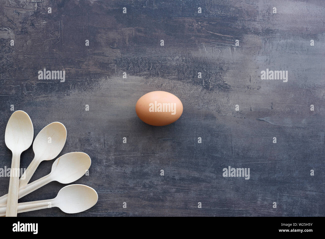 Vista dall'alto di uovo nel mezzo di sfondo di marmo della cucina. Naturale cucchiai di legno in un angolo. Copia dello spazio. Foto Stock