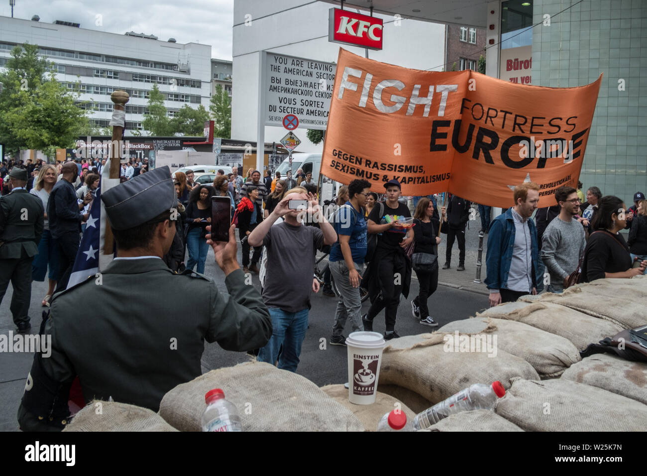 Berlino, Germania. 05 Luglio, 2019. I dimostranti presso l'ex Checkpoint Charlie tenere un banner con la scritta "Lotta Fortezza Europa" durante una marcia di protesta contro il razzismo sotto il motto "nero vive questione'. Una ragione per la demo è stato il ritrovamento del corpo di Rita Awour Ojunge, un richiedente asilo dal Kenya che era stato assente dal 7 aprile 2019, nel Land di Brandeburgo a metà giugno. I manifestanti hanno chiesto una spiegazione del caso sotto l'hashtag #SayHerName. Credito: Stefan Jaitner/dpa/Alamy Live News Foto Stock