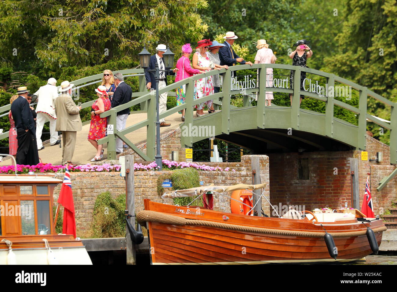 Spettatori vestita per l'occasione guardare la concorrenza di Phyllis corte a Henley Royal Regatta, Henley-on-Thames, Regno Unito Foto Stock