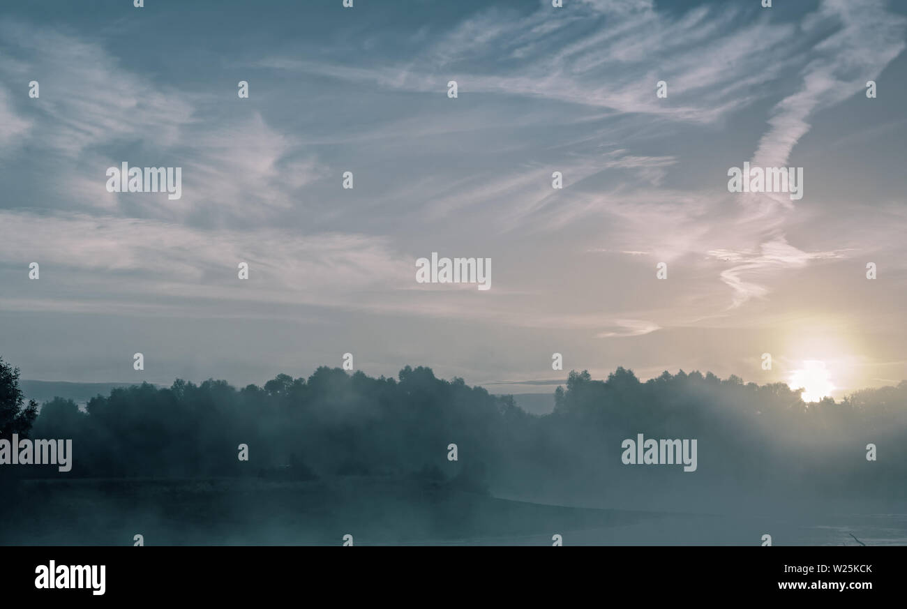 Tramonto su un piccolo lago con la nebbia sopra l'acqua. Foto Stock