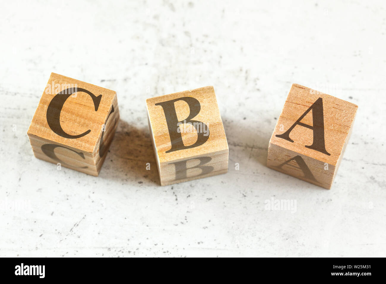 Tre cubi di legno con lettere CBA sta per un vantaggio di costo Valutazione sul pannello bianco. Foto Stock