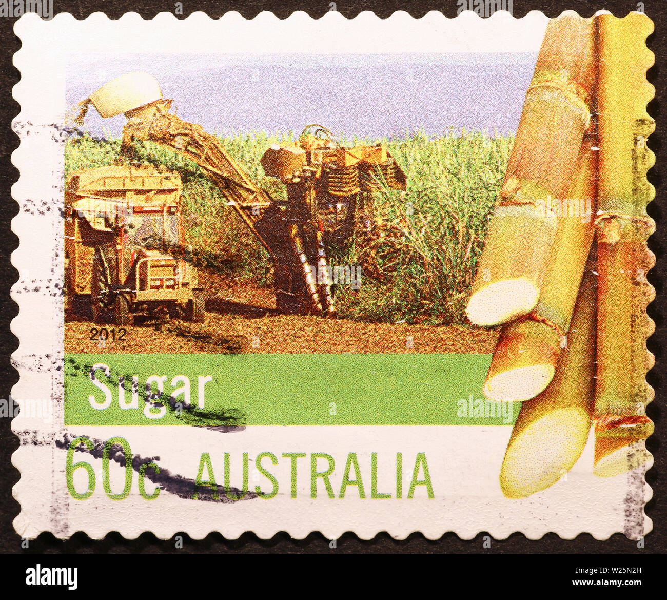 La canna da zucchero raccolta su australian francobollo Foto Stock