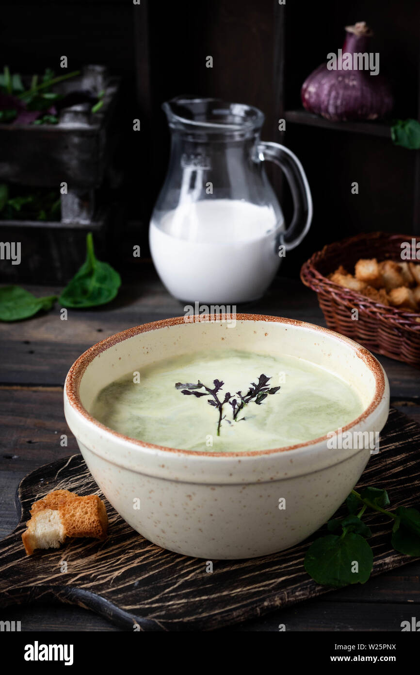 Zuppa cremosa purea di spinaci su sfondo scuro Foto Stock