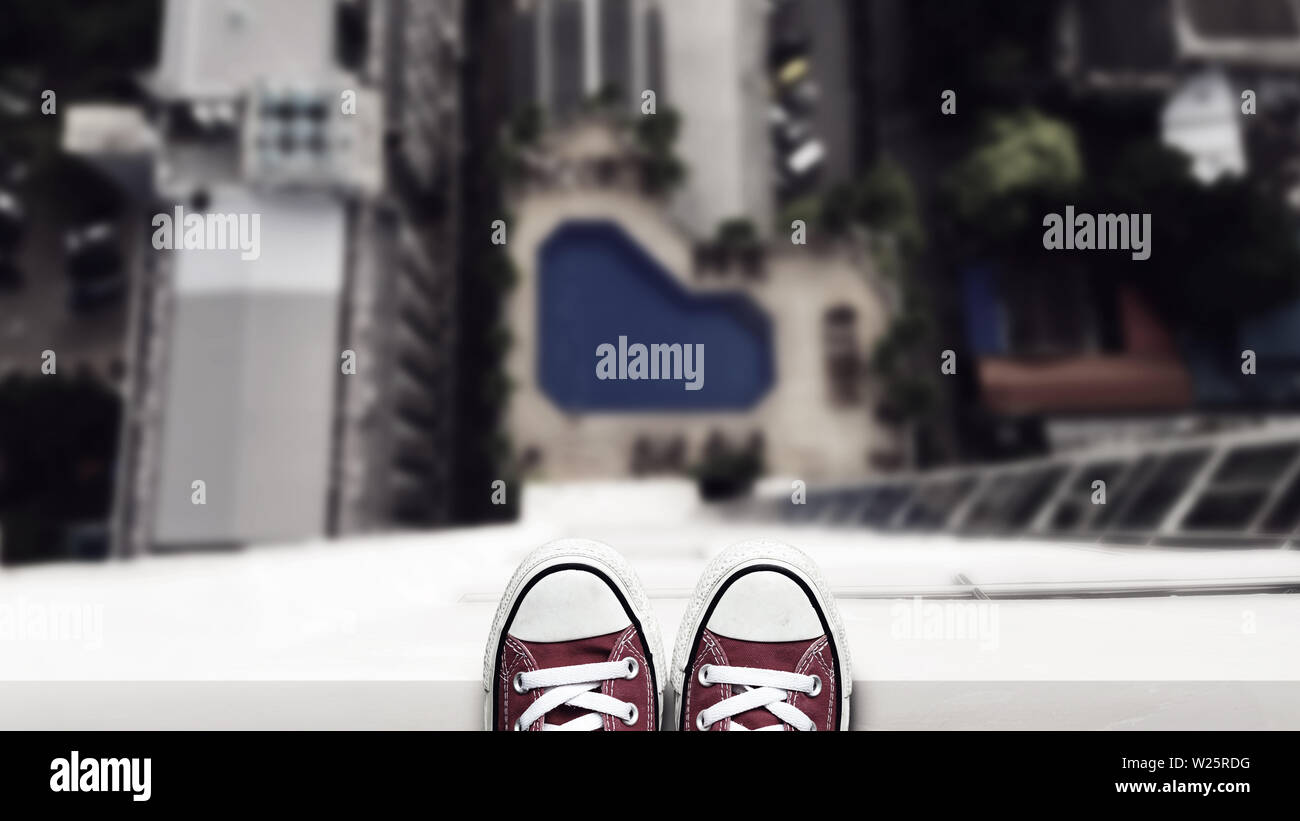 Depressione uomo stare sul bordo di un edificio alto guardando verso il basso in corrispondenza del suolo e contemplando il suicidio da edifici di salto. suicidio e Foto Stock