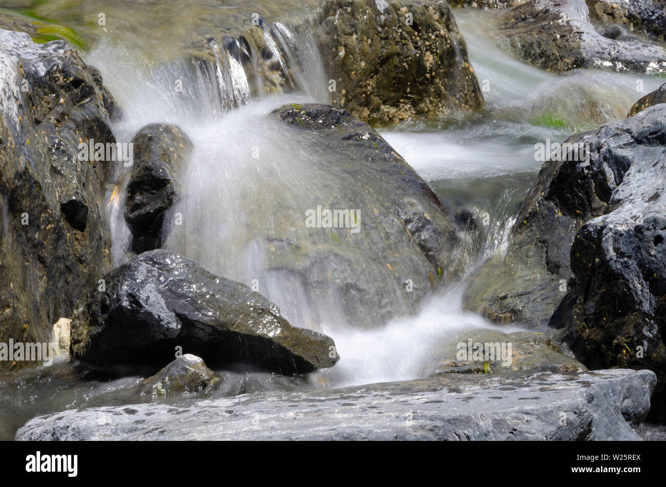 Veloce che scorre acqua nel flusso rocciose, Cape Palliser, Wairarapa, Isola del nord, Nuova Zelanda Foto Stock
