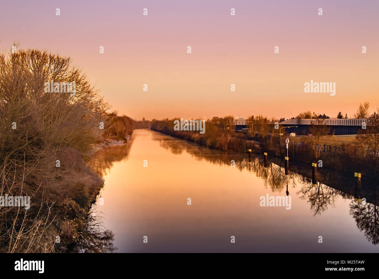 Berlino, Germania - 8 Febbraio 2018: Sunrise su di un canale a Berlino in una nebbiosa mattina con la luce del sole da favola. Foto Stock