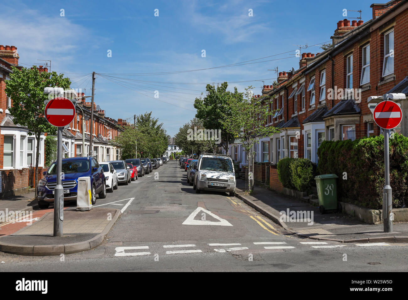 Parcheggio su strada con molte automobili parcheggiate fuori casa Foto Stock