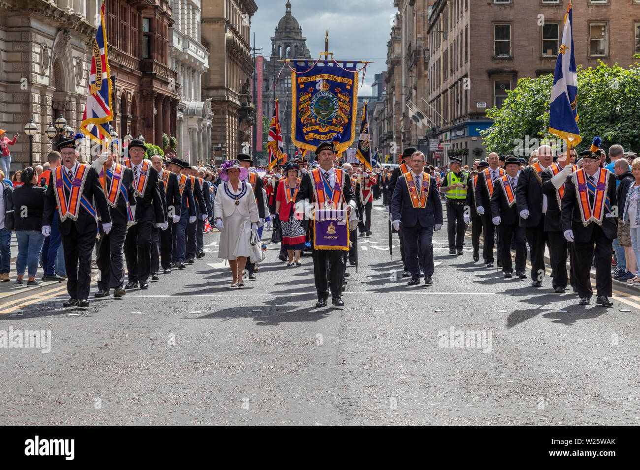 Il 2019 annuale di Orange Walk in Glasgow attrae migliaia di spettatori e partecipanti. La parata quest anno è di prendere un percorso modificato dopo un incidente nel 2018 in cui un sacerdote cattolico è stato battibecco su. Foto Stock