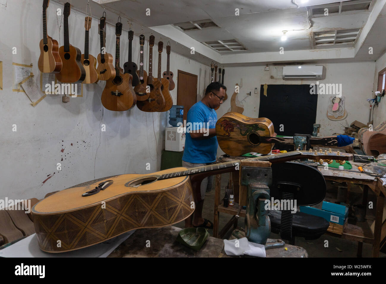 GIANYAR,BALI/INDONESIA-30 MAGGIO 2019: l'artigiano di chitarra stanno lavorando sulla pittura chitarre in una chitarra classica officina di proprietà di I Wayan Tuges in Guwa Foto Stock