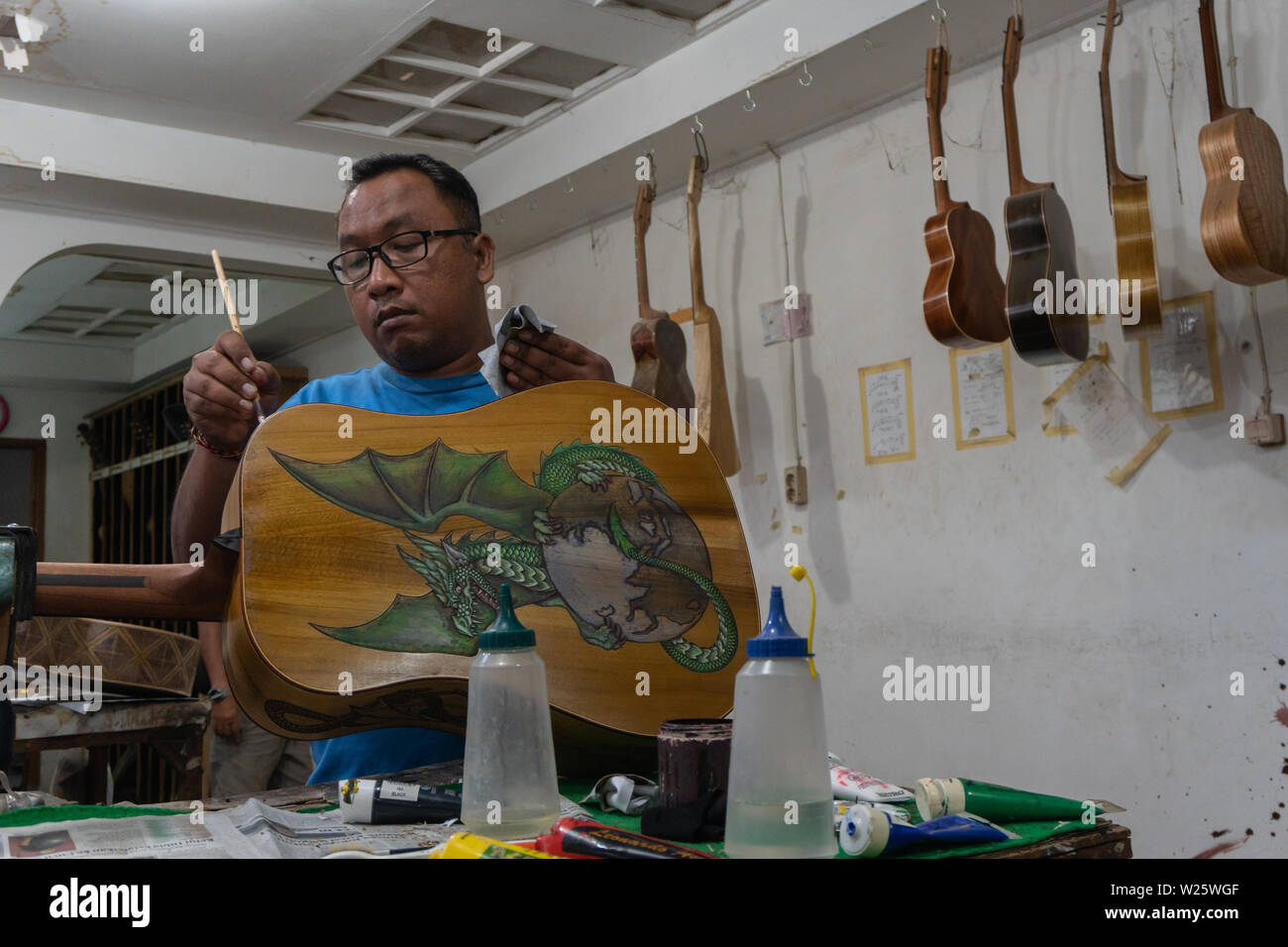 GIANYAR,BALI/INDONESIA-30 MAGGIO 2019: l'artigiano di chitarra stanno lavorando sulla pittura chitarre in una chitarra classica officina di proprietà di I Wayan Tuges in Guwa Foto Stock