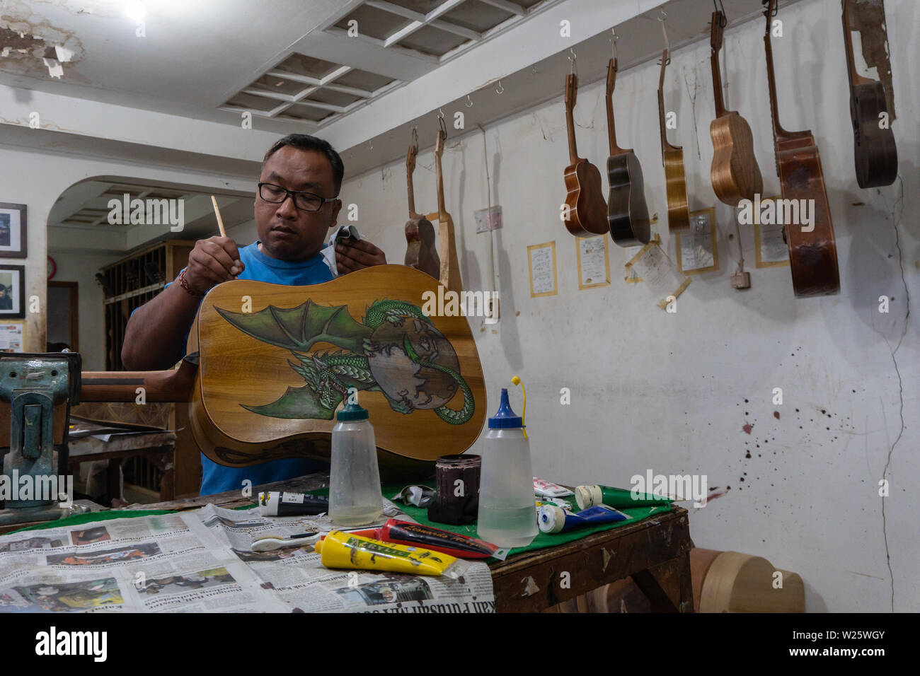 GIANYAR,BALI/INDONESIA-30 MAGGIO 2019: l'artigiano di chitarra stanno lavorando sulla pittura chitarre in una chitarra classica officina di proprietà di I Wayan Tuges in Guwa Foto Stock