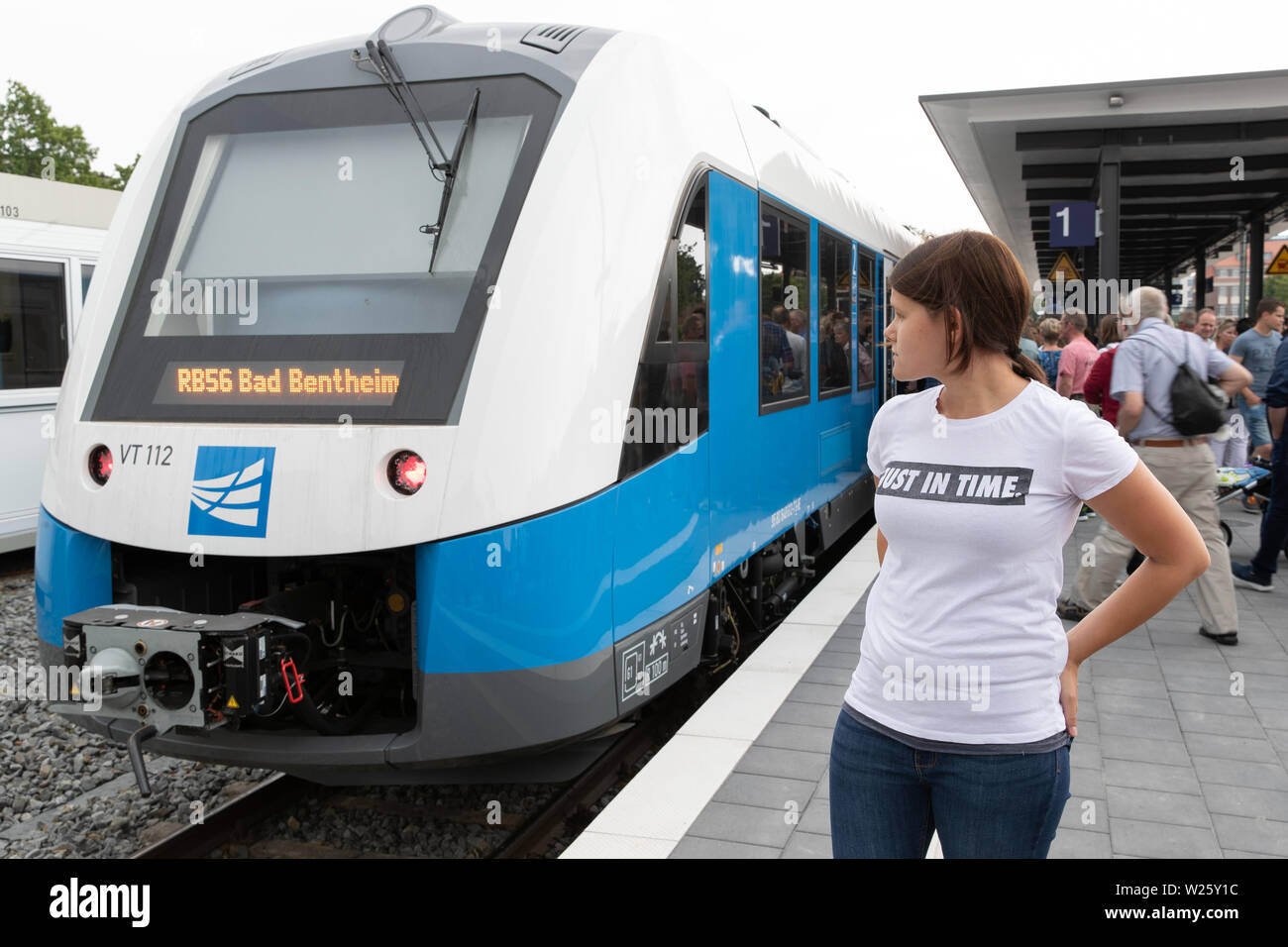 Nordhorn, Germania. 06 Luglio, 2019. Una femmina di passeggero con una T-shirt 'just in time' è in piedi presso la stazione di Nordhorn sulla via della RB 56 dell'Bentheimer Eisenbahn presso il cerimoniale di riavvio del treno passeggeri dal servizio di Bad Bentheim di Nordhorn. Dopo 45 anni, la ferrovia Bentheimer è ancora in esecuzione sui treni passeggeri sulla connessione, questo è il terzo della riattivazione di una linea ferroviaria in Bassa Sassonia. Credito: Friso Gentsch/dpa/Alamy Live News Foto Stock