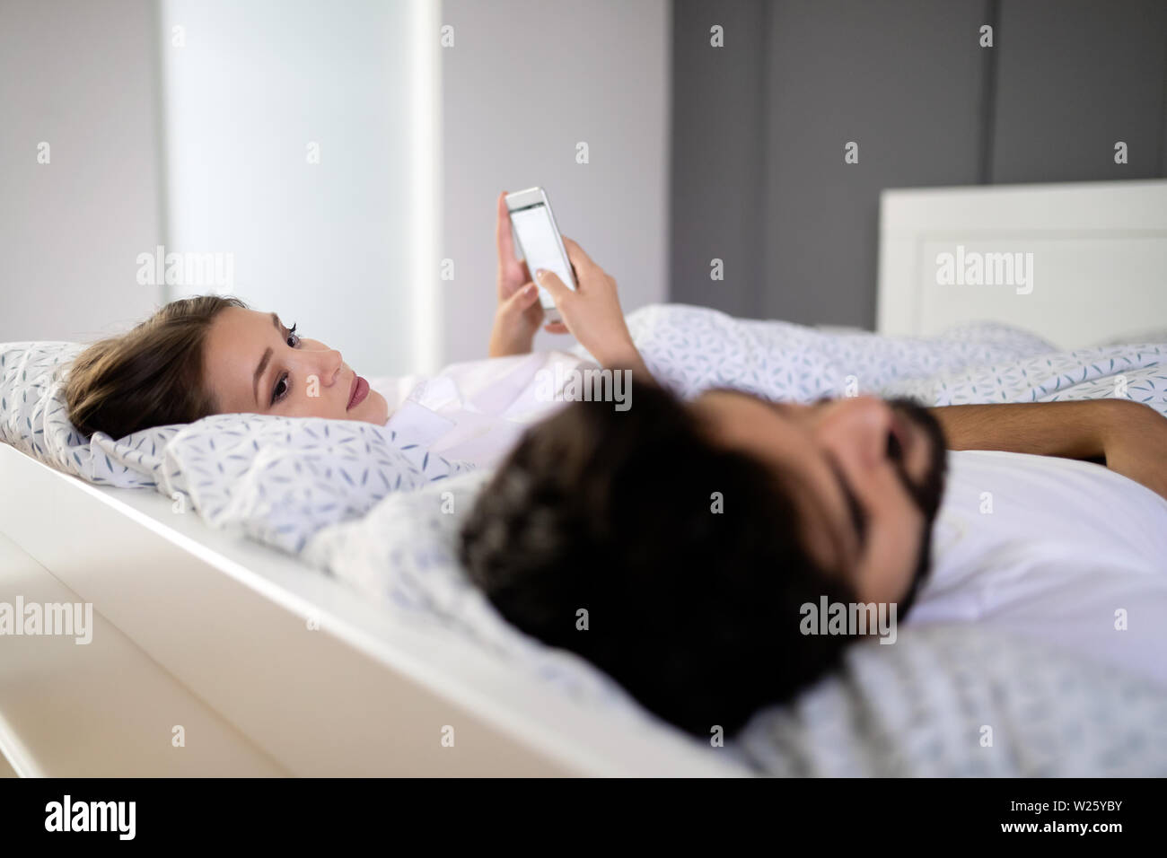 Giovane e bella moglie texting con amante sullo smartphone mentre mio marito  è in stato di stop Foto stock - Alamy