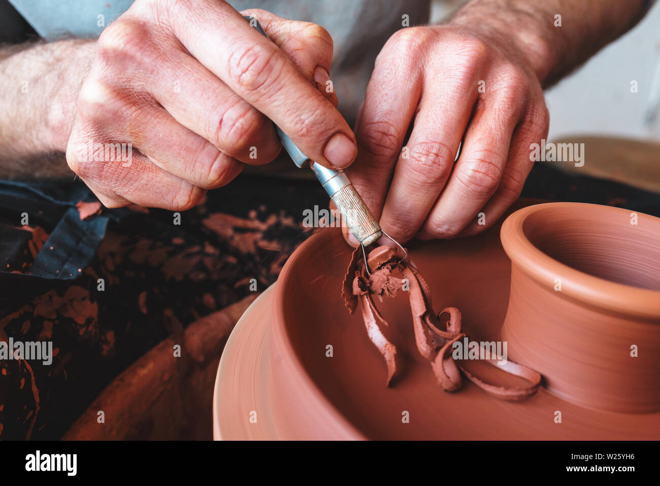 Professional potter rendendo bowl nel laboratorio di ceramica, studio. Foto Stock